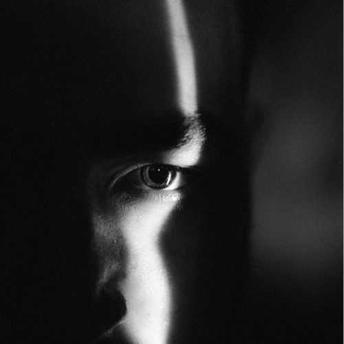 Portrait en clair-obscur d’un regard dans la lumière, illustrant le jugement du mot trop.