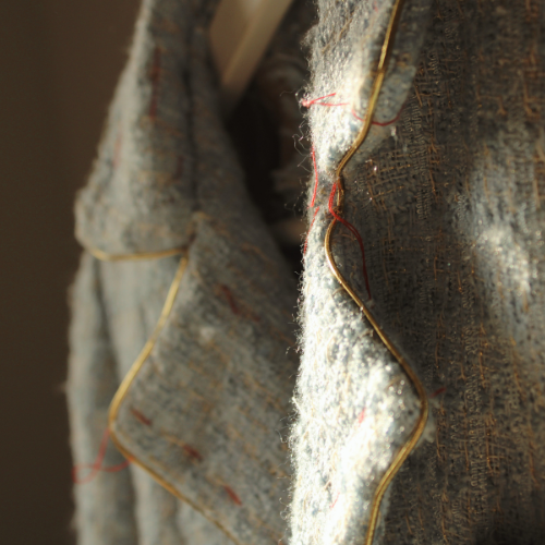 Portrait d'une pièce structurée, illustrant le vêtement comme langage social et la communication silencieuse de la posture.